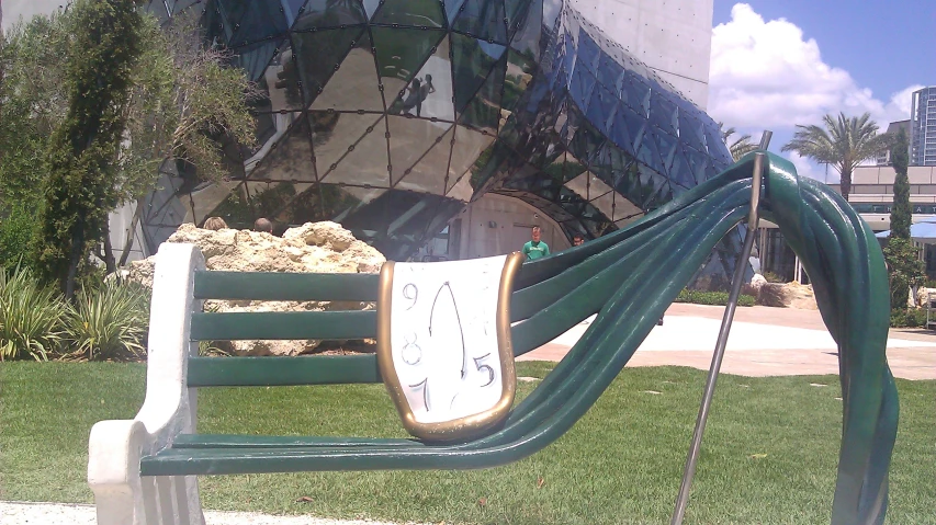 an old green wooden bench with writing on the side