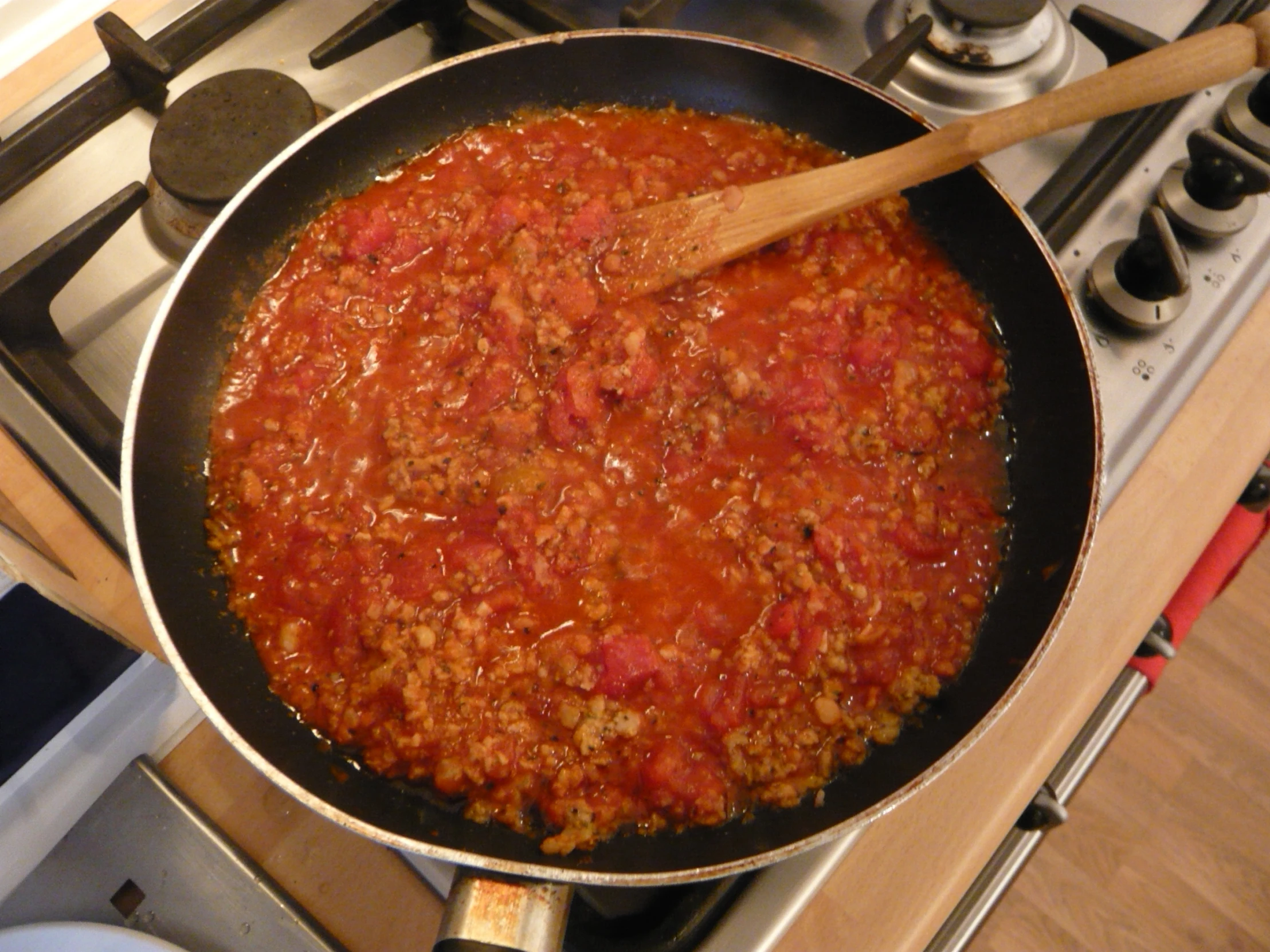 a pan with meat cooking on a stove top