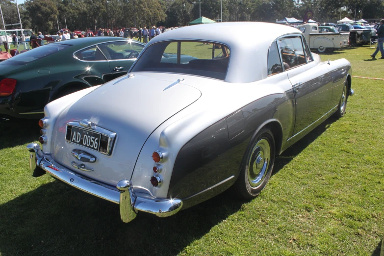 the old antique car is parked on the grass