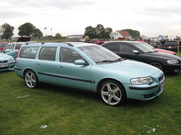 several car parked in the grass at a show