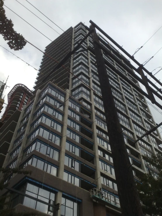 high rise building next to telephone wires on a cloudy day