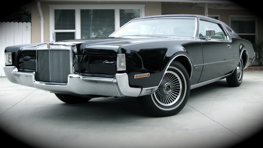 a large black car is parked in front of a building