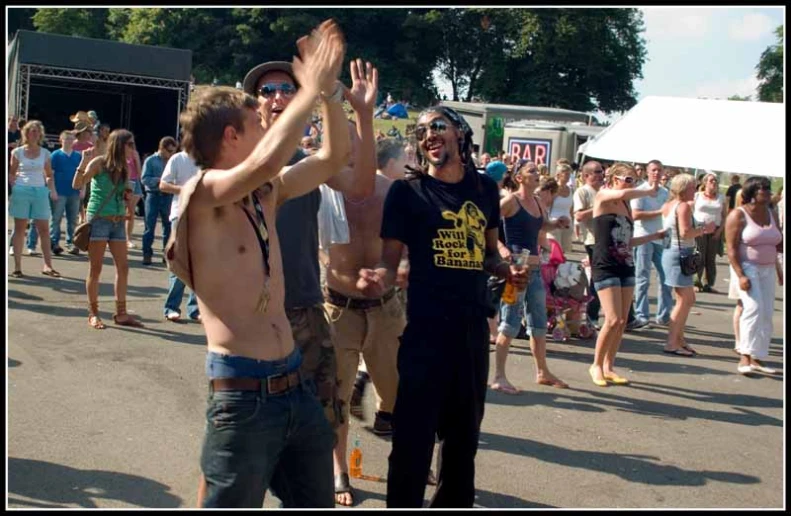 group of shirtless people are holding hands in the air