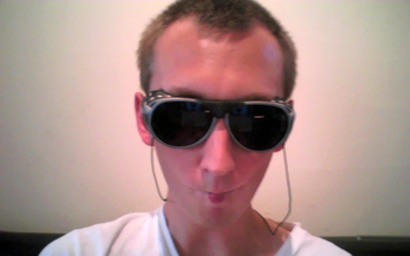 a man with large black sunglasses making a goofy face