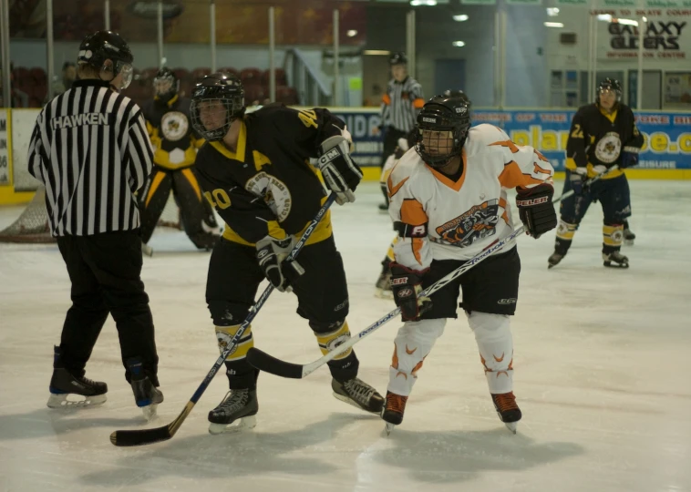 a group of children playing ice hockey in uniforms
