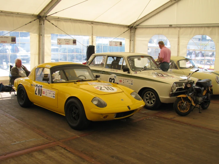 an old race car and other vintage cars on display