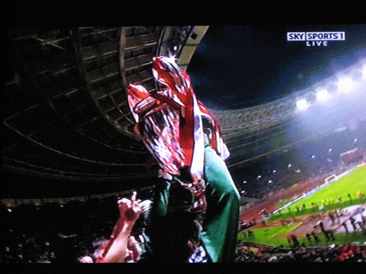 a man in the stands holds up his gloves