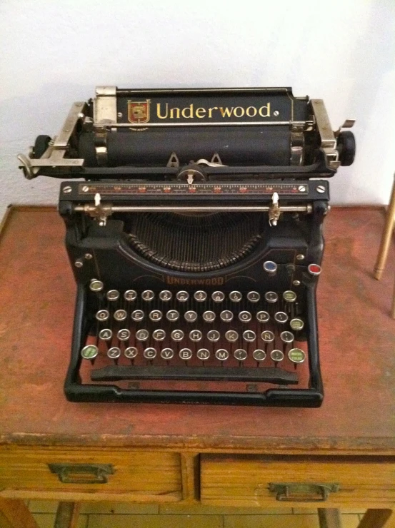 an old fashion typewriter and wooden dresser