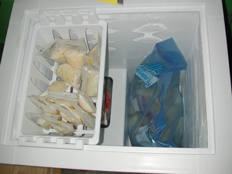 two containers containing various types of foods and an empty container with plastic wrapped bags