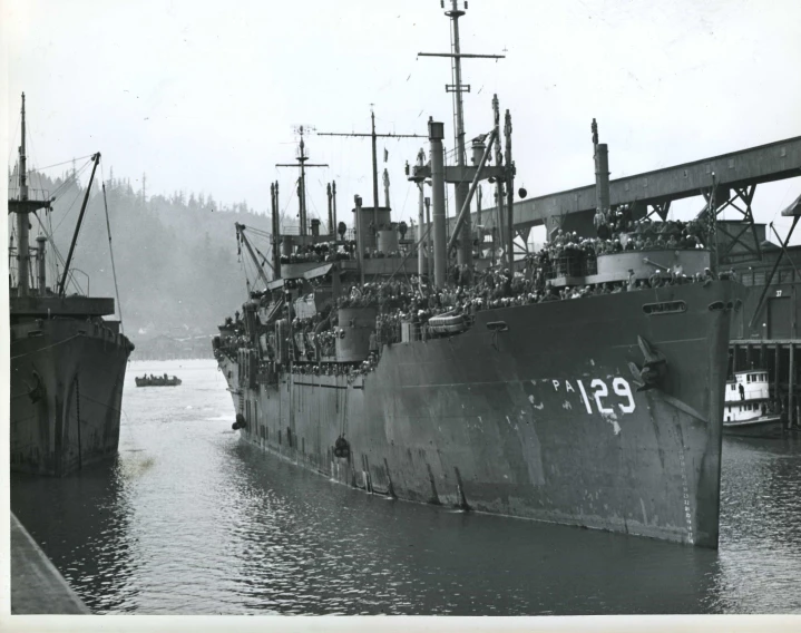 a large ship sitting at the dock next to other boats