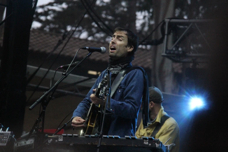 the man is standing near a microphone as he sings