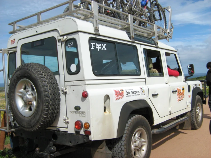 a white four door car with two bicycles on top