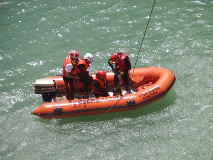 an orange inflatable raft with men standing on it