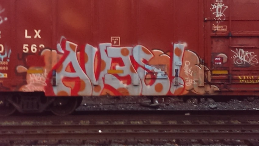 some sort of graffiti writing on the side of a red train