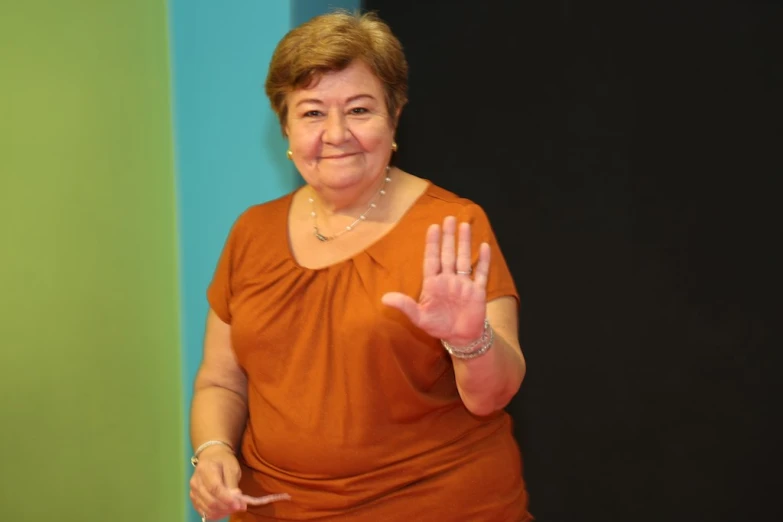 an older woman with her hand in the air