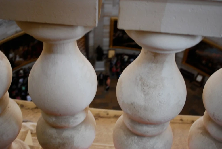 there is three tall white vases that are standing up