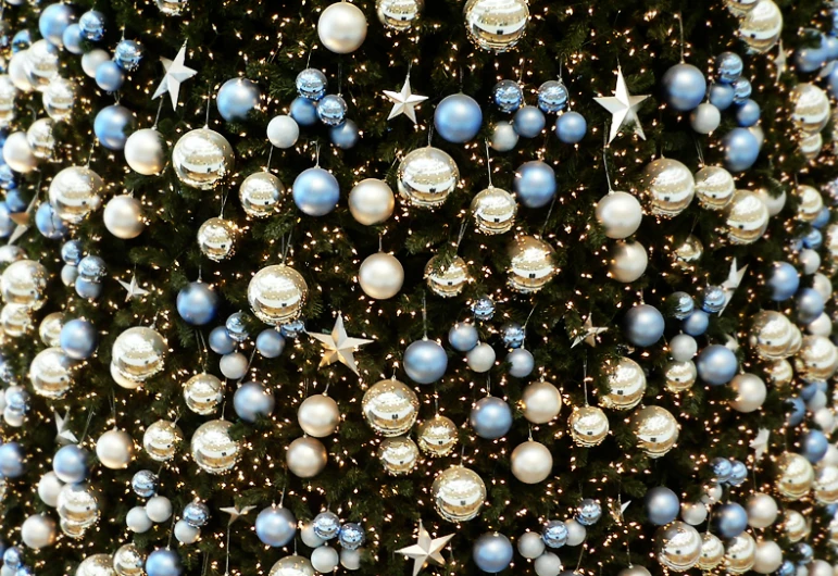 a giant christmas tree is decorated with lights and balls