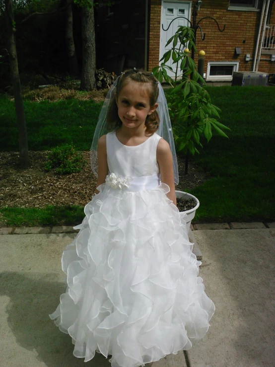 little girl in a flower girl dress on sidewalk