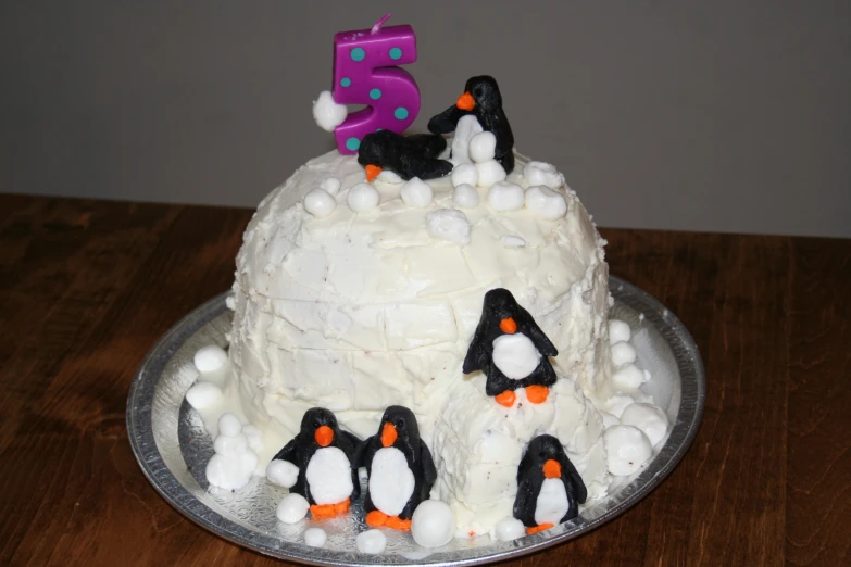 this cake features penguins and the number five