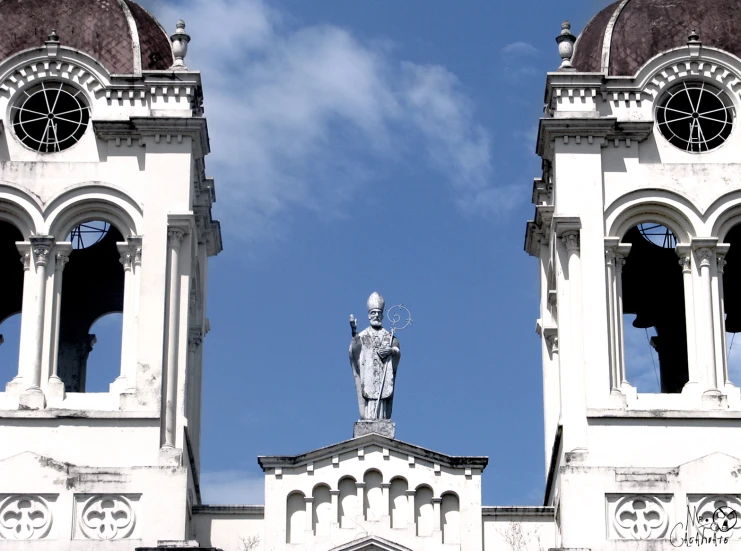 a large tall tower with two clocks and a statue