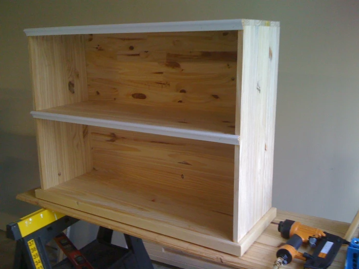 a wooden shelf with a couple of tools on top of it