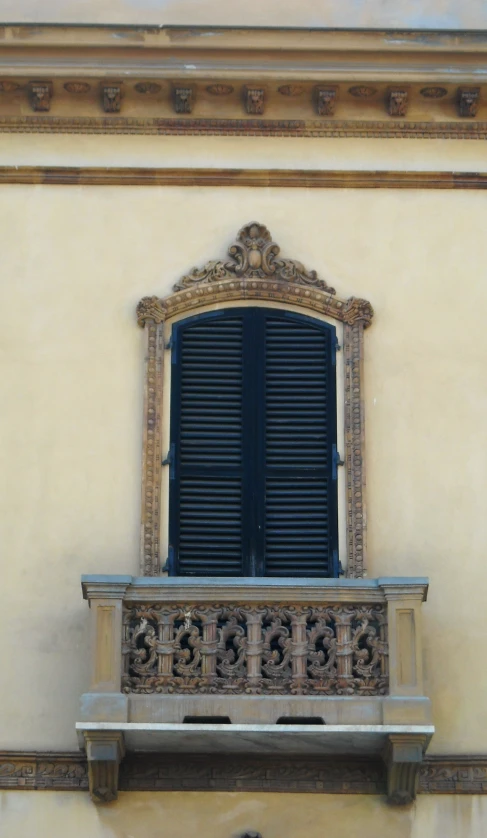 a window of a building with a wooden shutter