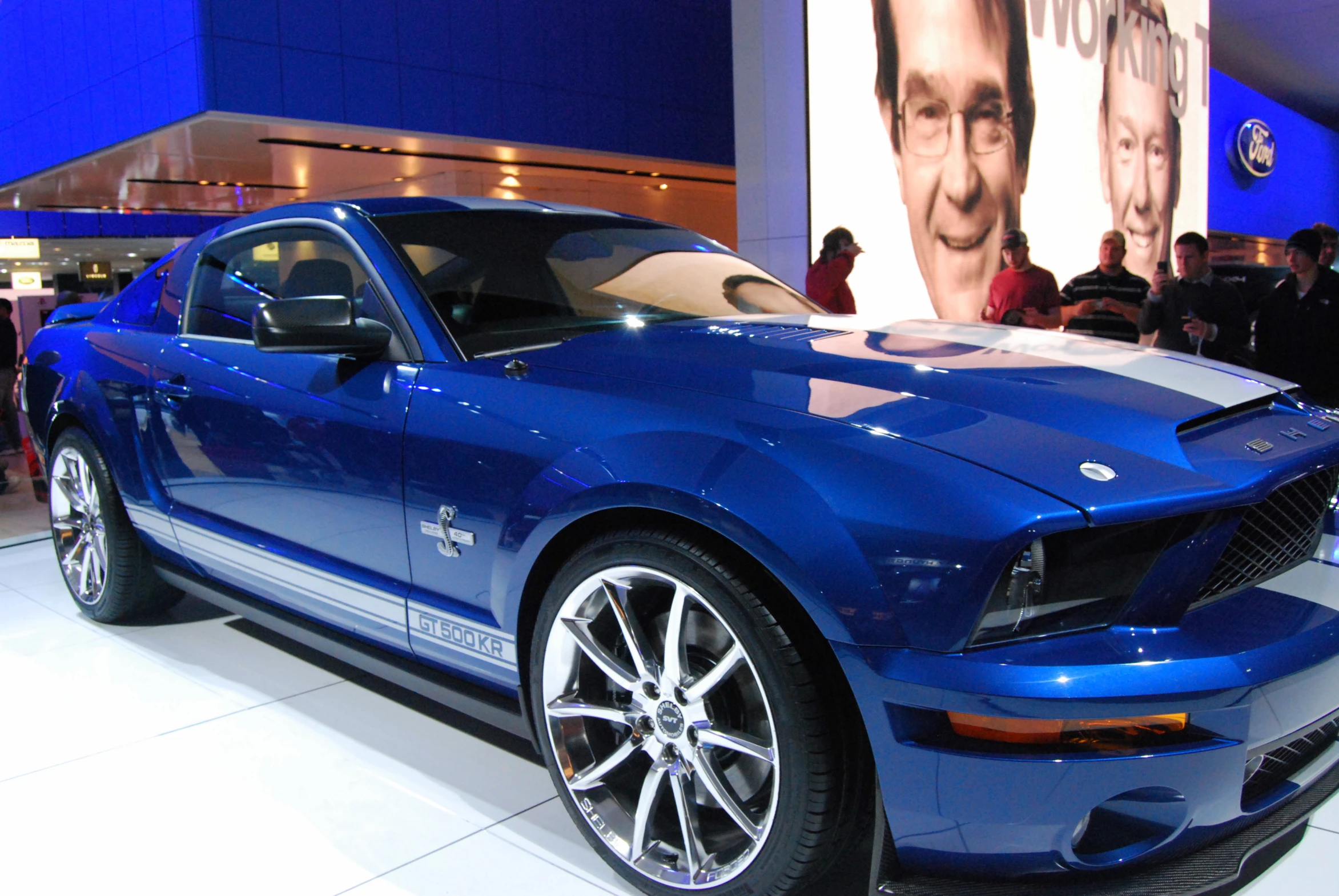 a blue sports car on display at a auto show