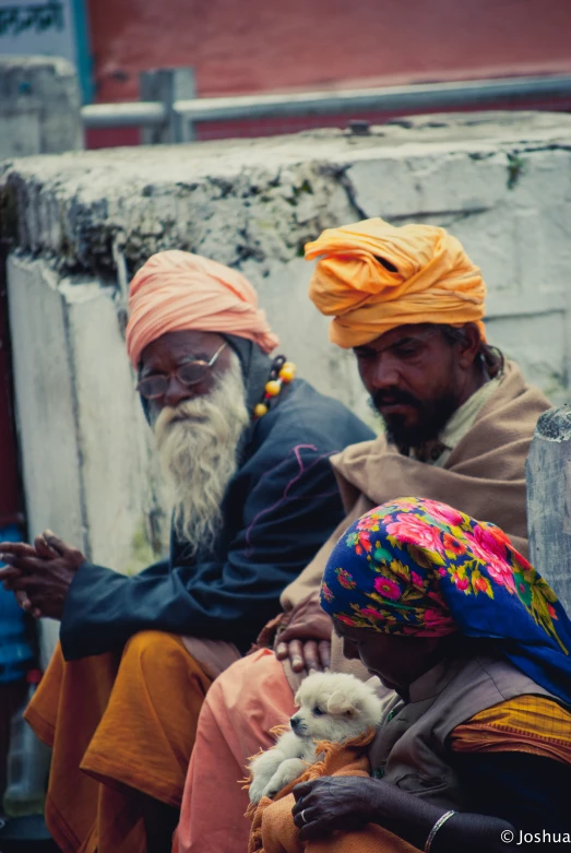 some old men are sitting together wearing bright outfits