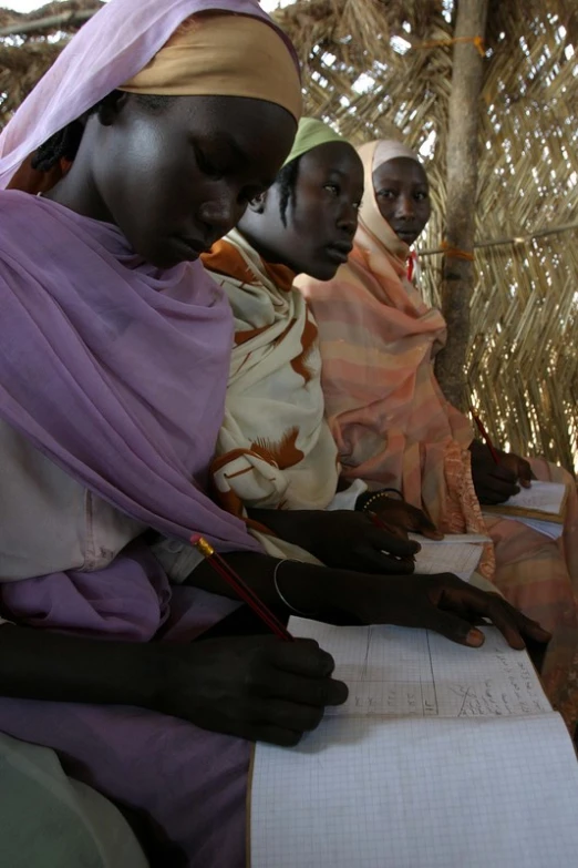 a group of women working on paper in an enclosure