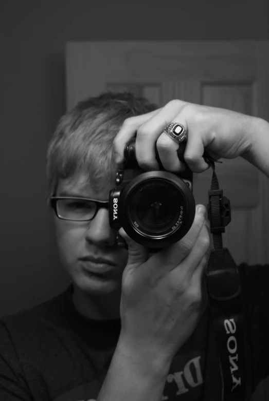 a young man is holding his camera up to the camera