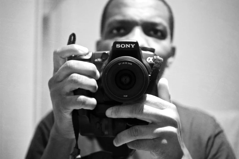 a person taking a picture in a mirror holding a camera