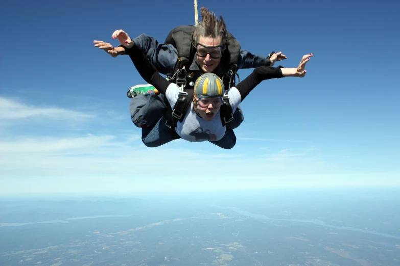 a man and woman are in the air doing parachute tricks