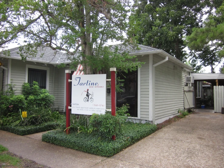 a po of a small, white house with a garden near it