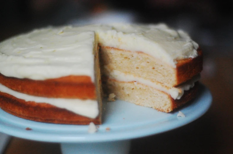 a cake with white frosting is shown on a cake plate