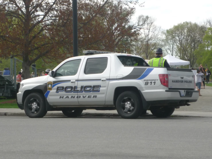 the police officer sits in the truck while talking to someone