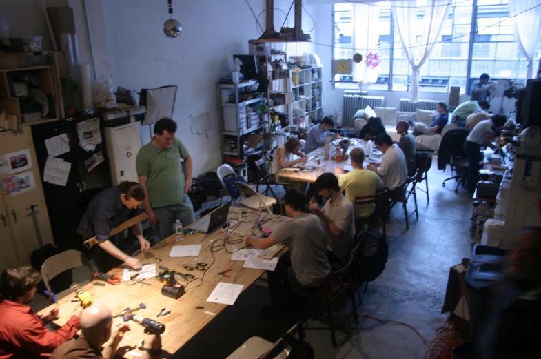 people are sitting at a table working on crafts