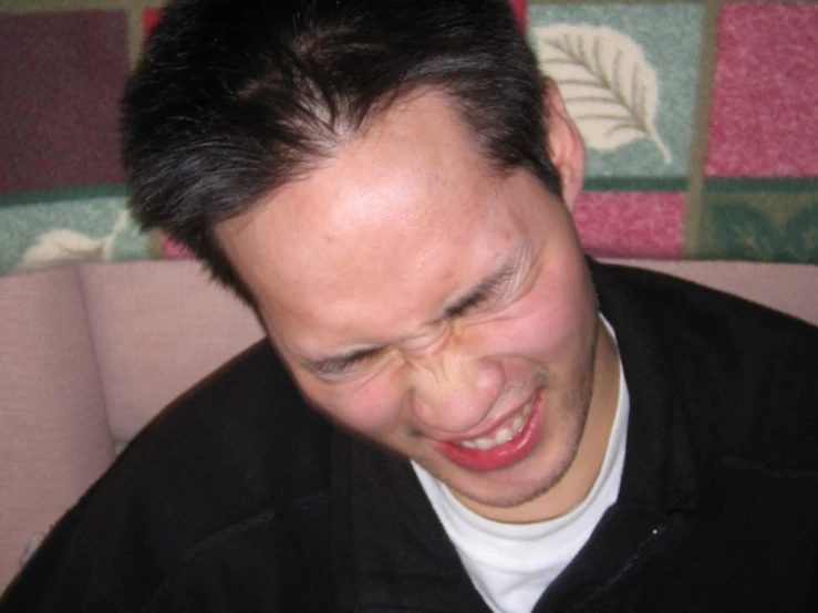 a man sitting down and smiling at the camera