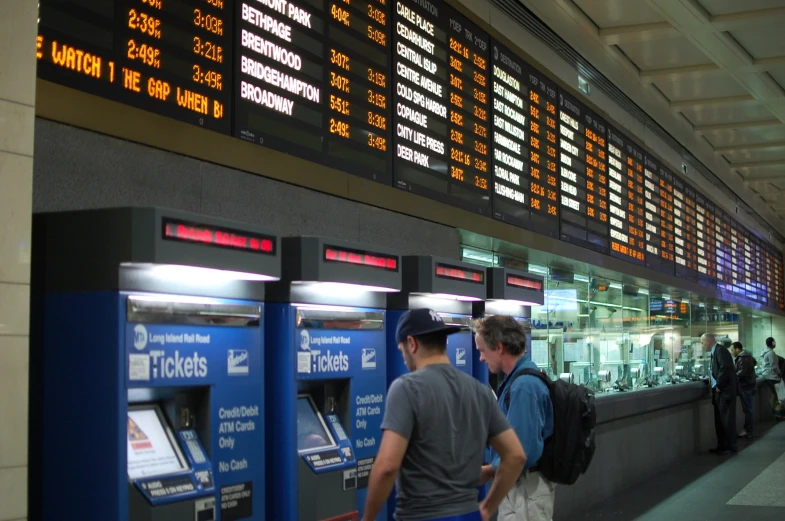 people wait in line at an airport, waiting for their next trip