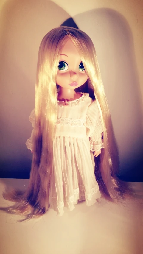 doll is dressed up and posed with blonde hair