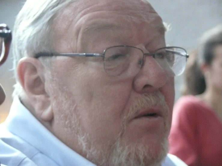 an elderly man is wearing glasses and looking off to the side