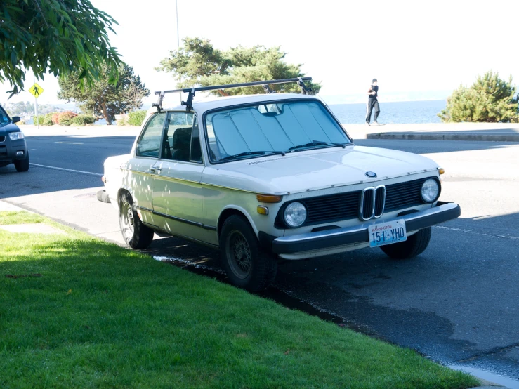an old bmw has been parked in a spot on the street