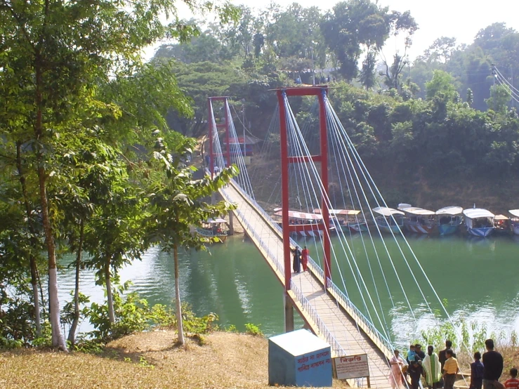 several people walking across a bridge over water
