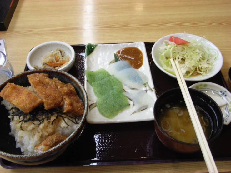 a wooden table topped with two bowls of food