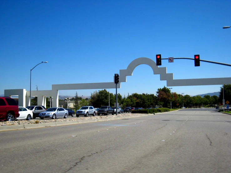 a large sculpture of shapes is located across the street from traffic signals