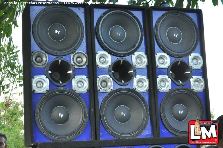 speakers hanging from the side of a tall speaker wall