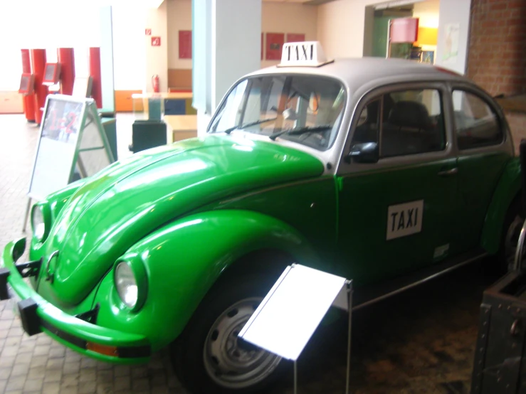 an old green car with taxi labels on it