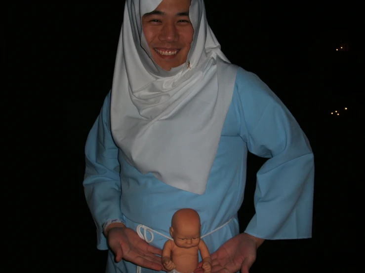 a woman in blue and white is holding a doll