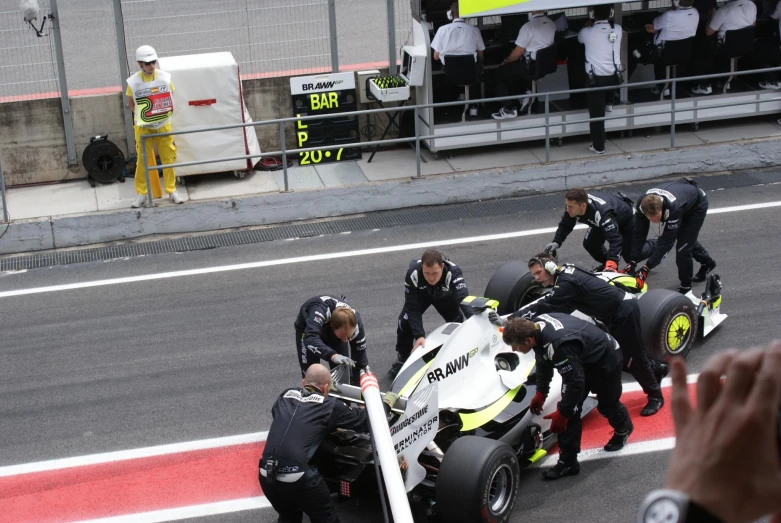 a race car is being worked on and the crew surrounding it