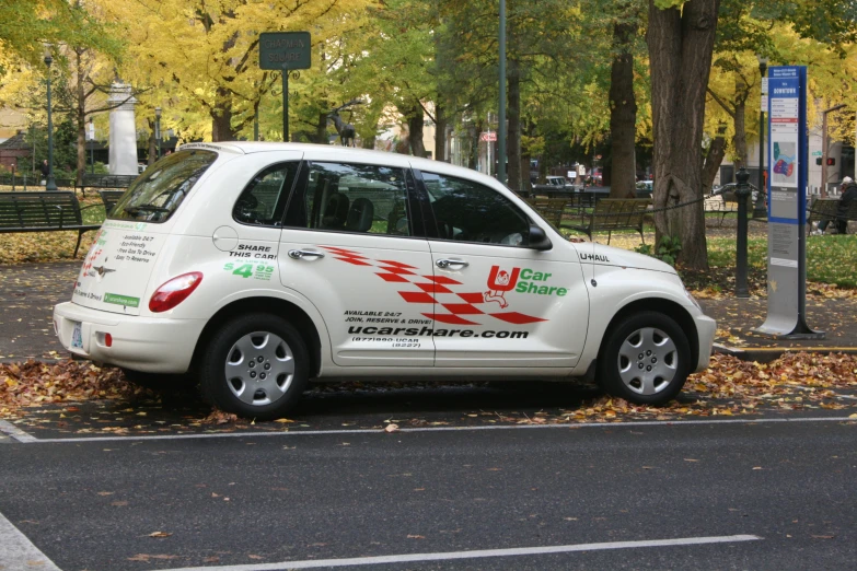 a car parked on the side of the road in front of trees