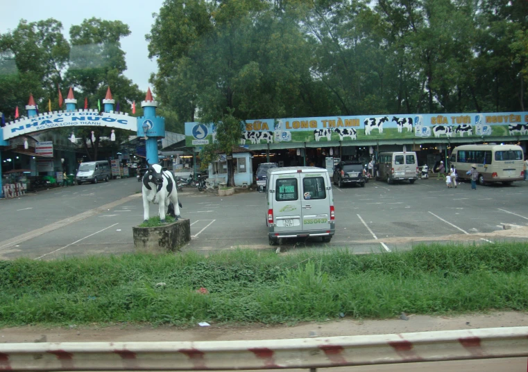 a white and black animal statue in the middle of a parking lot